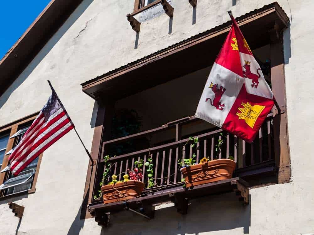 Spanish and us flags flying in the historic district along aviles street, st. augustine, florida, usa